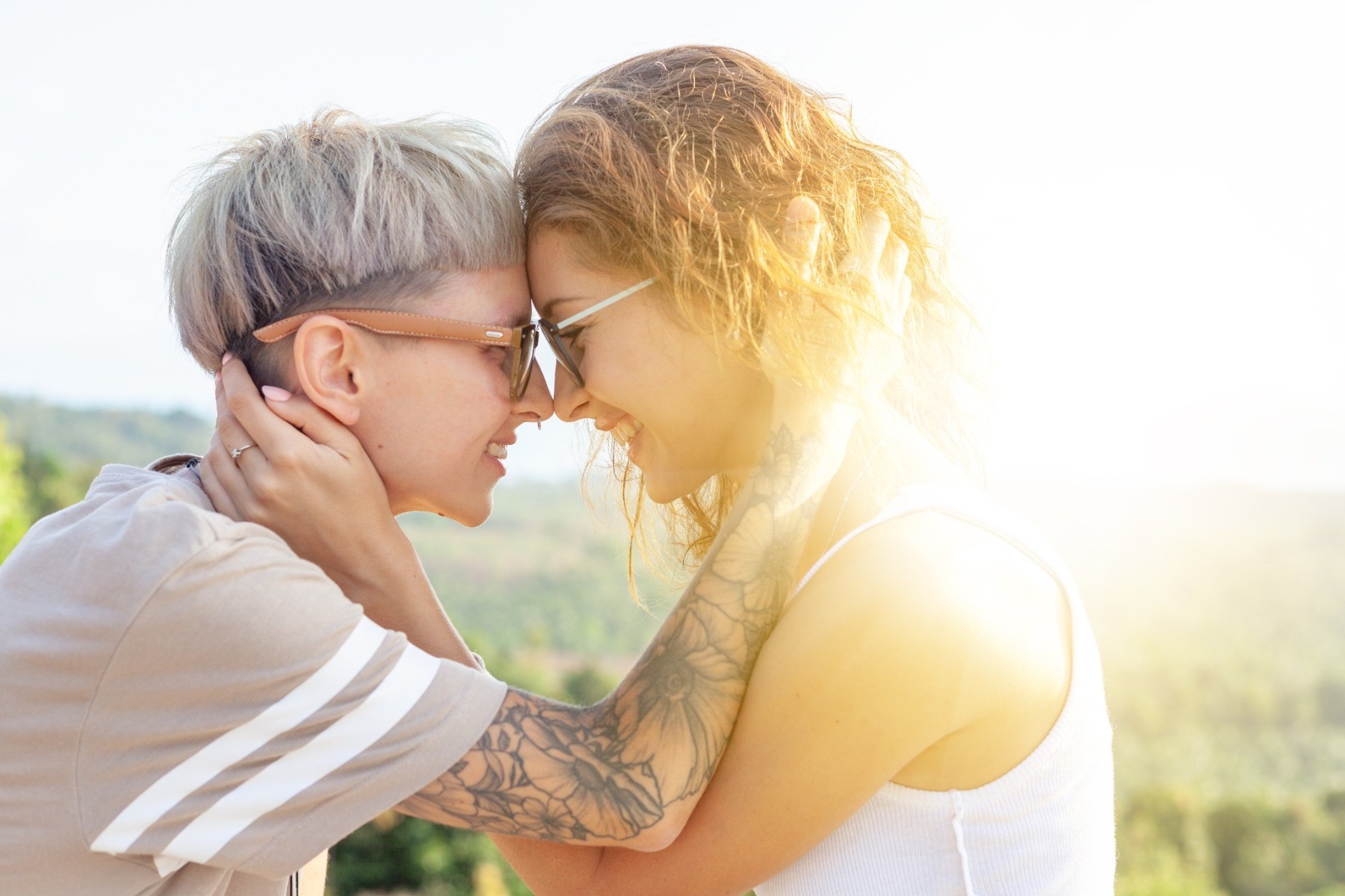 A lesbian couple smiling and touching noses