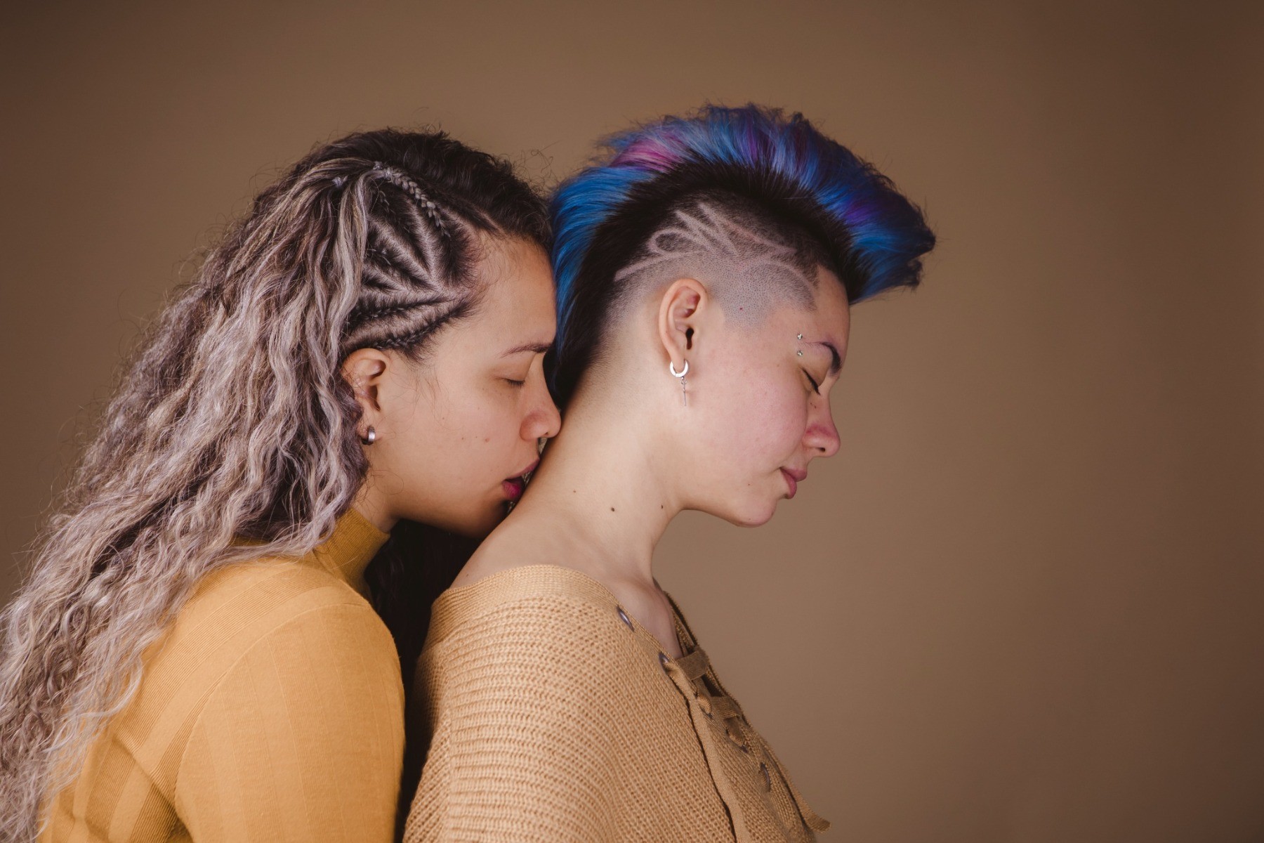 A woman kissing the back of her partner's neck because it is an erogenous zone